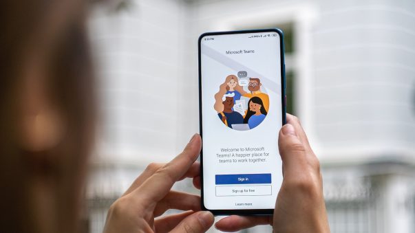 Woman holding a smartphone using Microsoft Teams